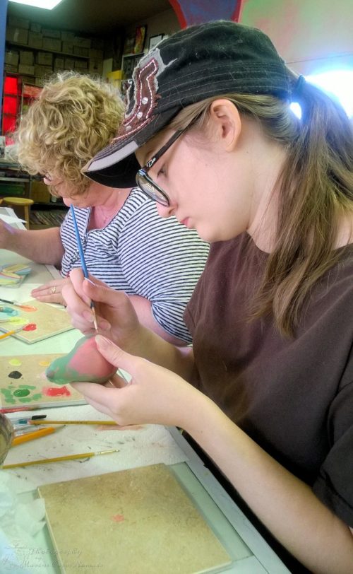 Munchkin painting her pottery bird